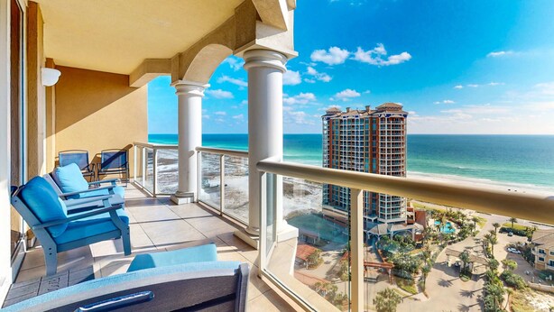 A balcony with a view of the ocean and a hotel building. - Gorgeous Resort Condo with Gulf Views, Shared Hot Tub, Pools, & Gym (Pensacola Beach)