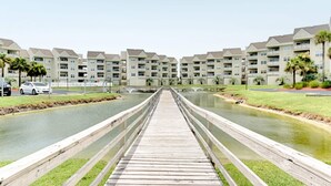 Un puente de madera que conduce a una zona residencial con varios edificios de apartamentos.
