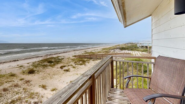 Ein Balkon mit Blick auf Strand und Meer.