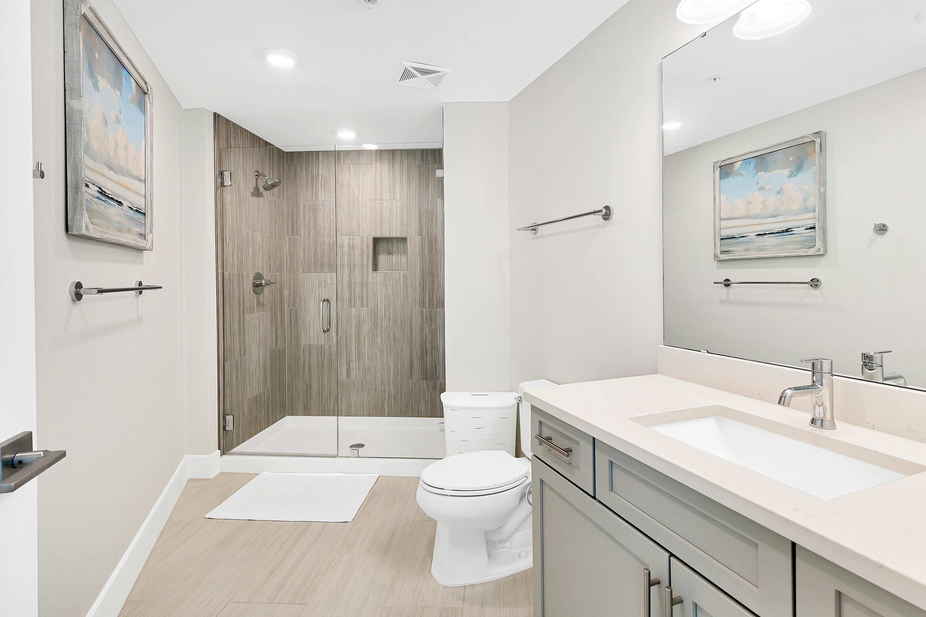 Une salle de bain moderne équipée d’une douche, de toilettes et d’un meuble-lavabo.