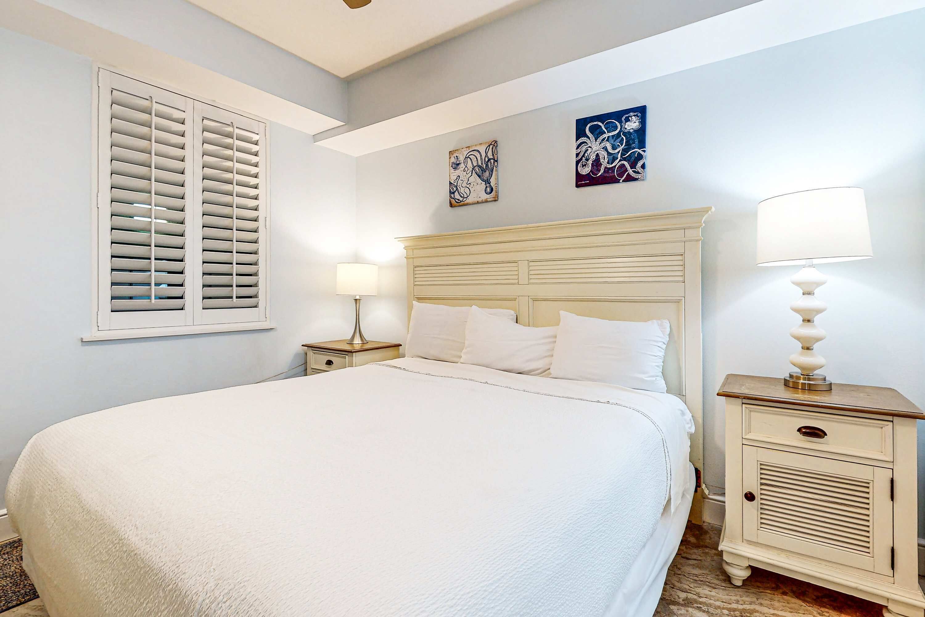 Une chambre à coucher avec un grand lit, deux tables de chevet et une tête de lit.