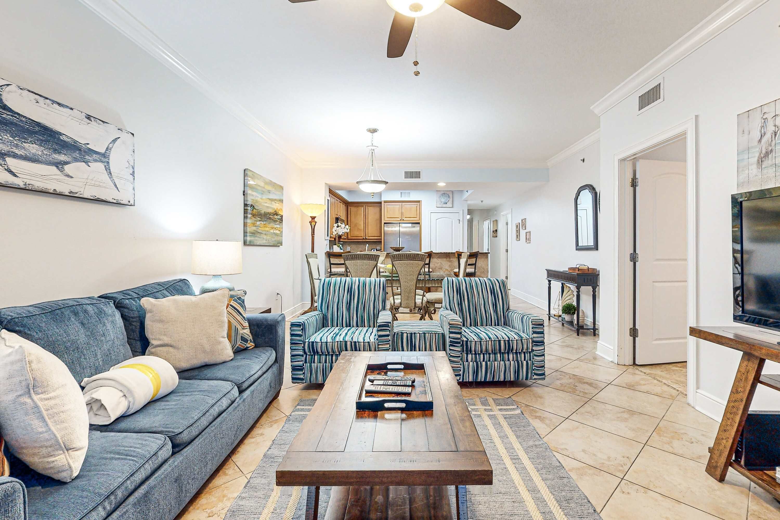 A living room with a sofa, armchairs, a coffee table, and a TV stand.