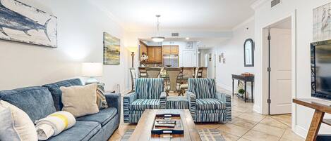 A living room with a sofa, armchairs, a coffee table, and a TV stand.