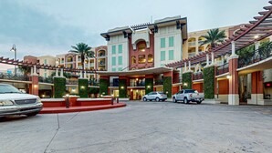 Ein Hotel mit Innenhof, mehreren Balkonen und einem überdachten Gang.