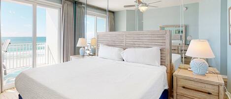 Una cama grande con cabecera de madera en una habitación con vistas al balcón.
