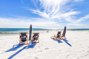 A beach with two beach chairs labeled "Sea Guide" and a clear view of the ocean. - Lovely and Convenient Home In Beachfront Complex w Shared Pool, WiFi, AC, & W&D (Fort Walton Beach)