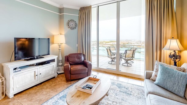 Una sala de estar con televisor, sillón de cuero, sofá y un comedor con mesa y sillas.
