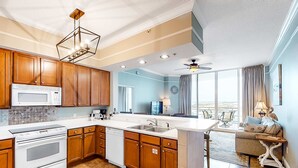 Una cocina moderna con armarios de madera, una estufa blanca y una isla grande con un lavamanos.