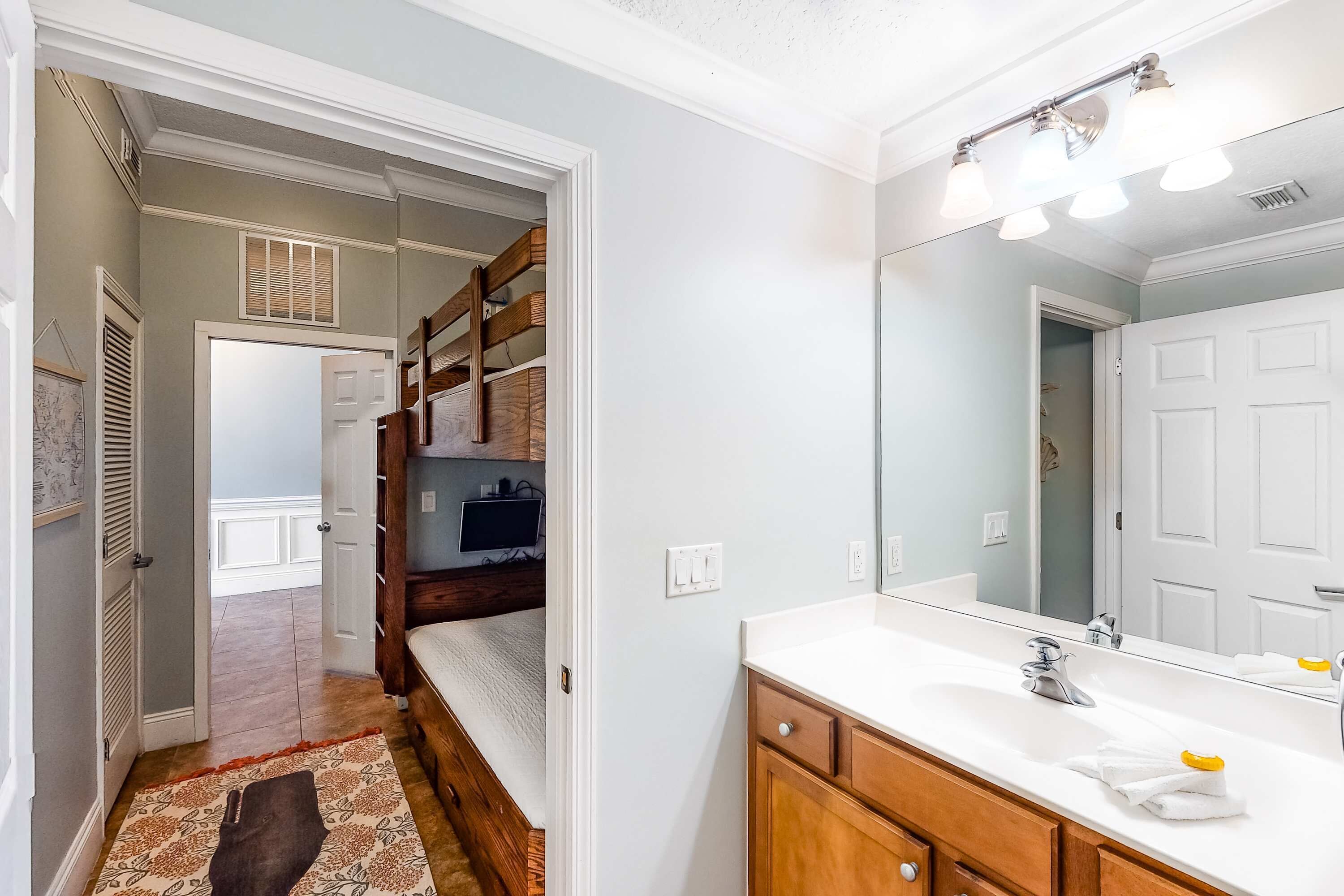 Une salle de bain avec un lavabo blanc, un meuble-lavabo en bois et un miroir.