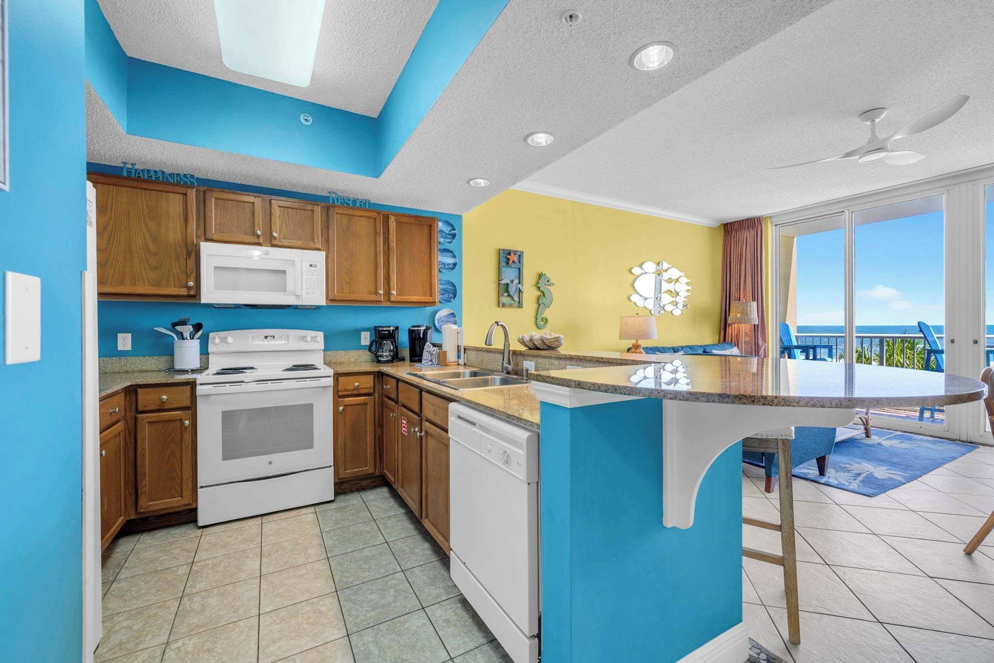 Une cuisine moderne avec des meubles en bois, des appareils électroménagers blancs et un mur d’accent bleu.