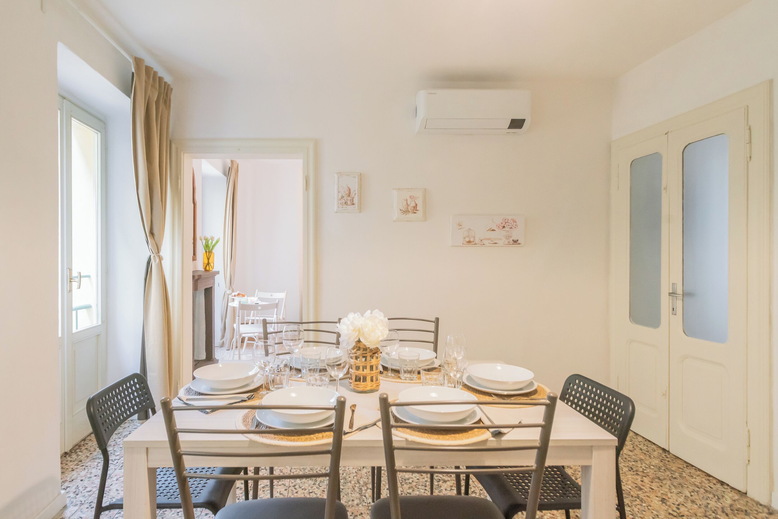 A dining area with a table set for four, chairs, and a decorative vase.