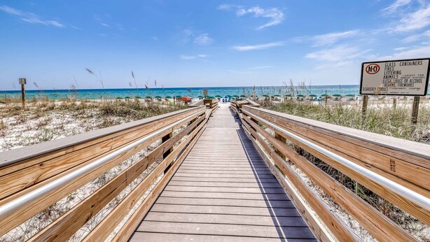A wooden boardwalk leading to the beach with a 'No Glass Containers' sign. - Beautiful beachfront home with shared pool and beach access (Fort Walton Beach)