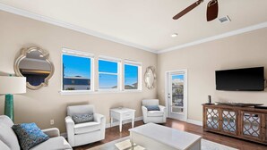 Una sala de estar con sofá, dos sillones, una mesita de centro, televisor y aparador.