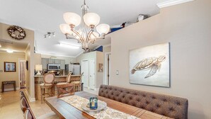 Ein Essbereich mit Holztisch, gepolsterten Bänken und einer Chandelüster.