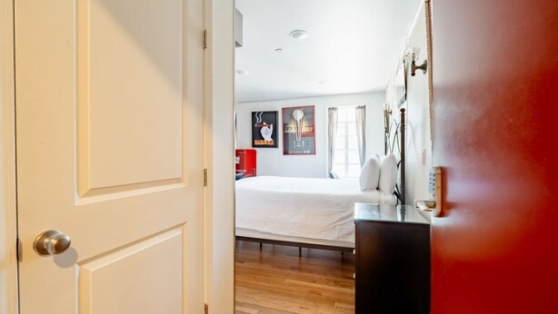 Une chambre d’hôtel avec un lit, un bureau et une porte rouge.