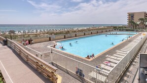 En swimmingpool med udsigt over stranden og havet.
