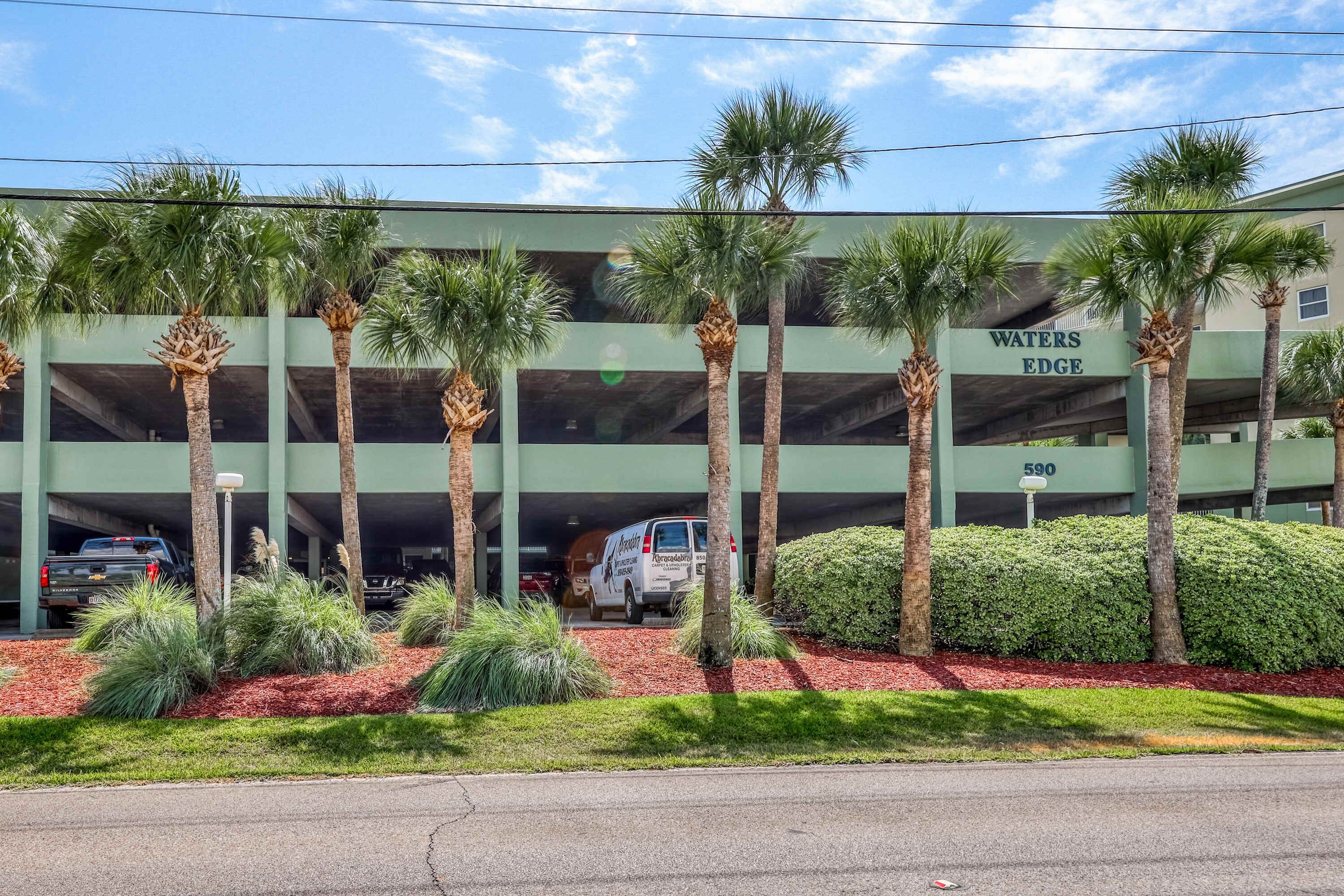 A building with a sign reading "WATERS EDGE" and a parking garage.
