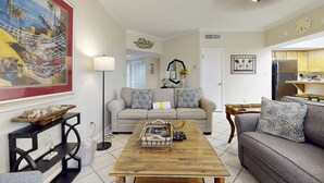 A living room with a sofa, a coffee table, and a painting on the wall. - Modern Resort Home with Shared Hot Tub, Pool, Free WiFi, and Beach Access (Miramar Beach)