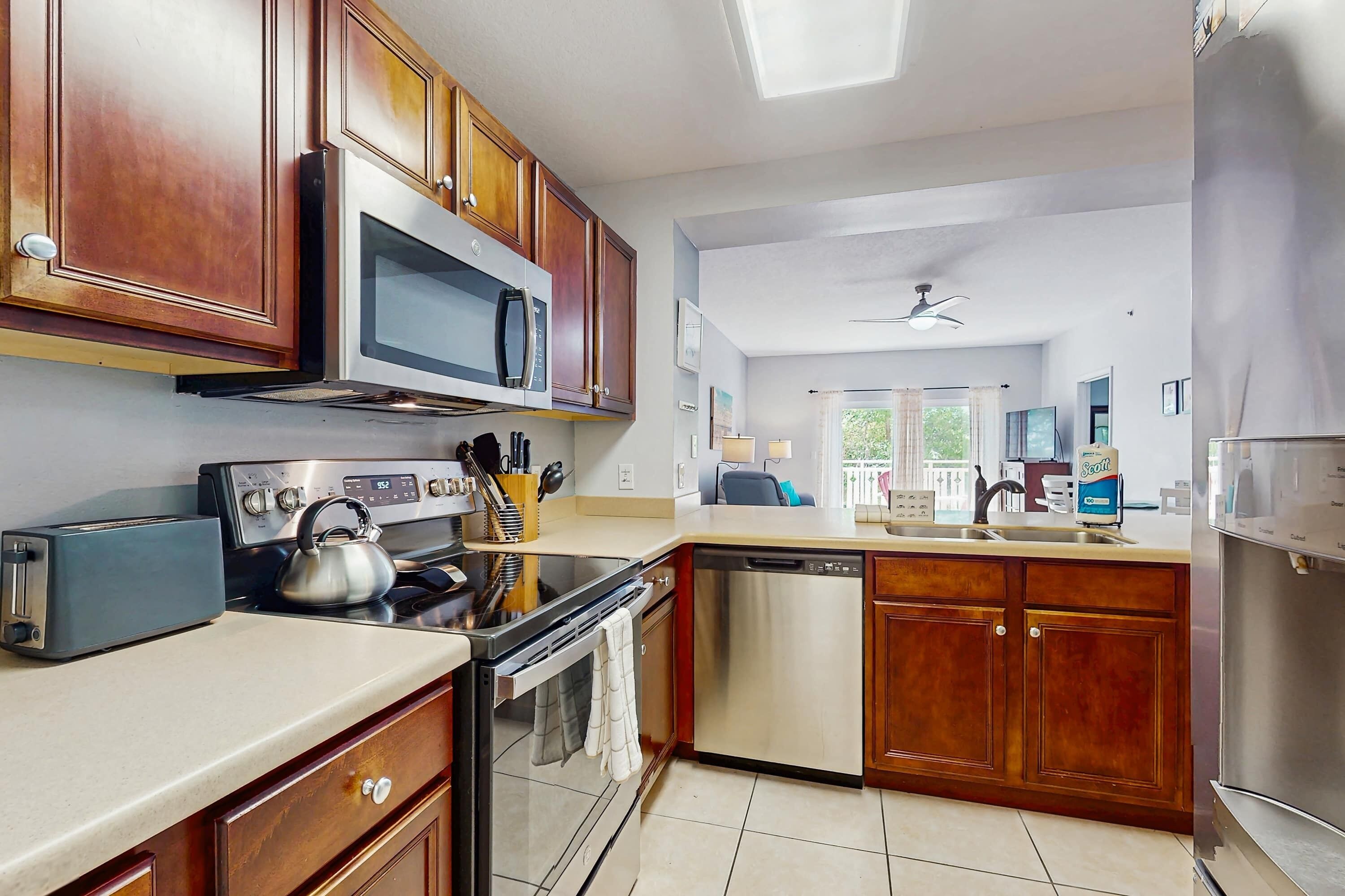 A modern kitchen with wooden cabinets, stainless steel appliances, and a dishwasher.