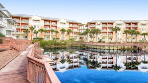 A hotel with multiple floors, balconies, and a pool area. - Waterfront Home Close to Beach w/ Shared Pool, Hot Tub, Free WiFi, & Central AC (Mexico Beach)