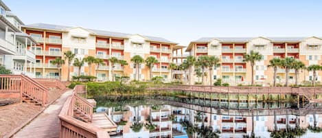 A hotel with multiple floors, balconies, and a pool area.