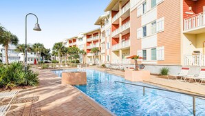 A swimming pool with lounge chairs and a bell on a pole. - Waterfront Home Close to Beach w/ Shared Pool, Hot Tub, Free WiFi, & Central AC (Mexico Beach)