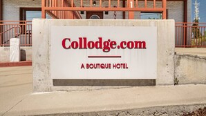 Une enseigne pour Collodge.com, un hôtel de charme, avec une base en béton et des éléments décoratifs rouges.