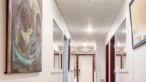Un couloir doté d’un plancher en bois, d’un banc et d’œuvres d’art accrochées aux murs.