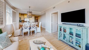 Una sala de estar con comedor, televisor y estantería.