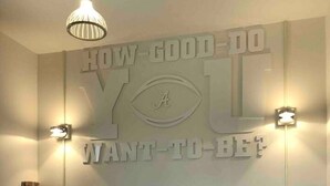 A bedroom with a bed, a wall with motivational text, and two wall-mounted lamps. - Alabama Boutique Hotel: #6 w/ TV Rm, PacMan Arcade (Tuscaloosa)