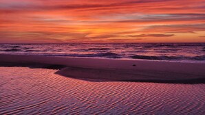 A beach with waves and a sunset. - Newly constructed beachfront home with panoramic bay & Gulf views (St. George Island)