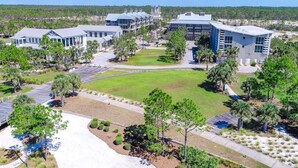 Un campus con edificios modernos, un césped central y jardines circundantes.