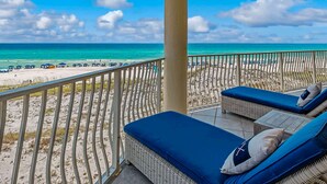 A balcony with wicker furniture and a view of the beach. - Stunning Beachfront condo with two pools, a hot tub, onsite gym and tennis/pickleball courts. (Santa Rosa Beach)