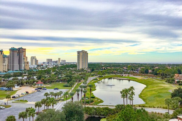 A cityscape with a large body of water, palm trees, and high-rise buildings. - Gorgeous coastal studio with shared pool, near shopping and golf (Miramar Beach)