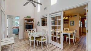 A dining area with a table and chairs, a ceiling fan, and a view into another room. - Gulf view home across the street from the beach - walk to shops,restaurants (Santa Rosa Beach)
