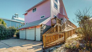 A pink house with a wooden staircase and a garage. - Gulf view home across the street from the beach - walk to shops,restaurants (Santa Rosa Beach)