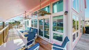 A covered outdoor deck with seating and a ceiling fan. - Gulf view home across the street from the beach - walk to shops,restaurants (Santa Rosa Beach)