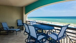 Een balkon met uitzicht op de oceaan en het strand.