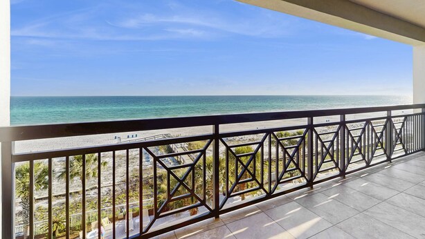 Een balkon met uitzicht op het strand en de oceaan.