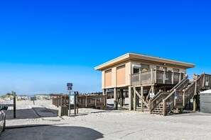 Une tour de surveillance située sur la plage, dotée d’un escalier en bois et d’un panneau indiquant « Promenade 21A ».