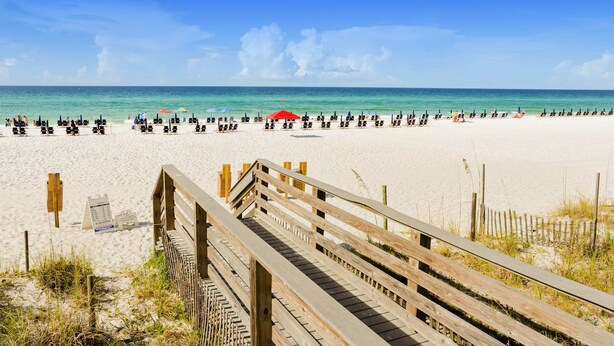 A beach with a wooden boardwalk leading to the sand, a clear blue sky, and a calm sea. - Luxurious condo near downtown, beach, & golf with pools & tennis (Miramar Beach)