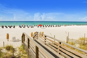 A beach with a wooden boardwalk leading to the sand, a clear blue sky, and a calm sea. - Luxurious condo near downtown, beach, & golf with pools & tennis (Miramar Beach)