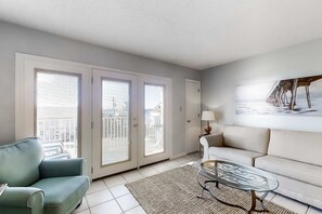 A modern living room with a sofa, a coffee table, and a painting on the wall. - Large waterfront cottage, Private pool, Close to entertainment (Miramar Beach)