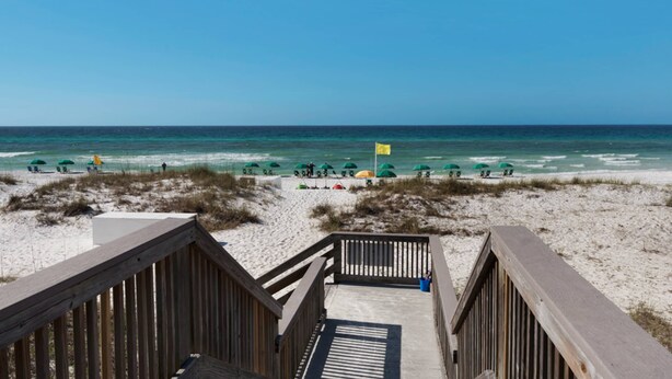 A wooden boardwalk leading to a sandy beach with umbrellas and beach chairs. - Large waterfront cottage, Private pool, Close to entertainment (Miramar Beach)