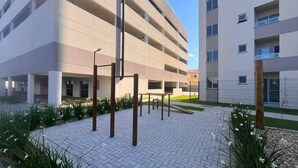 A multi-story parking structure with a paved walkway and greenery. - Solarium Beach Club - Apartamento T1.302 (Itapoá)