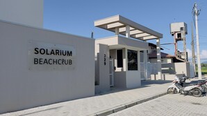 A modern building with a sign reading 'SOLARIUM BEACH CLUB'. - Solarium Beach Club - Apartamento T1.302 (Itapoá)