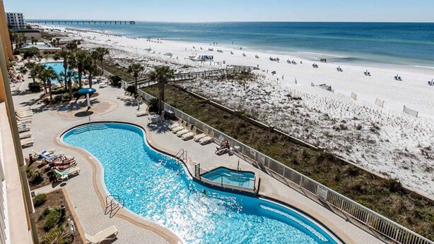 A pool area with a view of the beach and ocean. - Gorgeous beachfront condo, private balcony, shared pool and beach access (Fort Walton Beach)