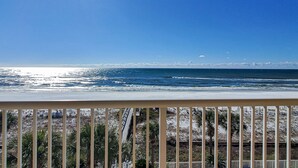 A balcony with a view of the ocean and a train in the distance. - Gorgeous beachfront condo, private balcony, shared pool and beach access (Fort Walton Beach)