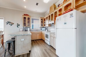 Eine moderne Küche mit Holzausstattung, integriertem Backofen und Kühlschrank.