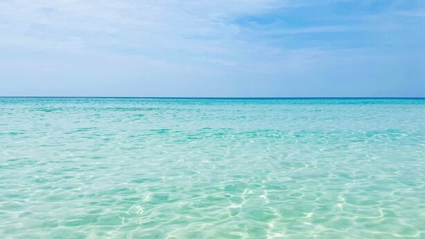 Una vista despejada de un mar turquesa bajo un cielo azul.